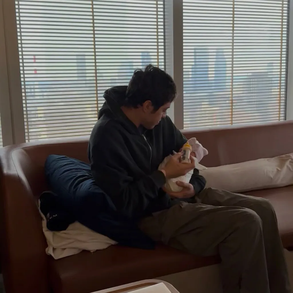 Pete Davidson feeding a baby from a bottle.
