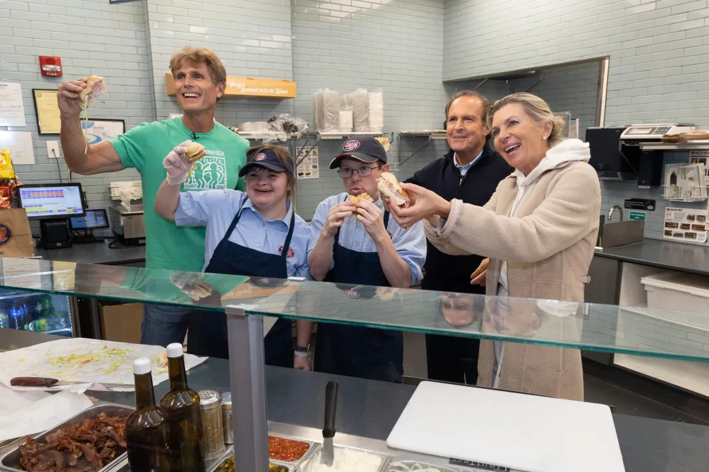 Anthony Kennedy Shriver, Peter Cancro, Linda Cancro, and two Best Buddies employees sharing subs at Jersey Mike's.