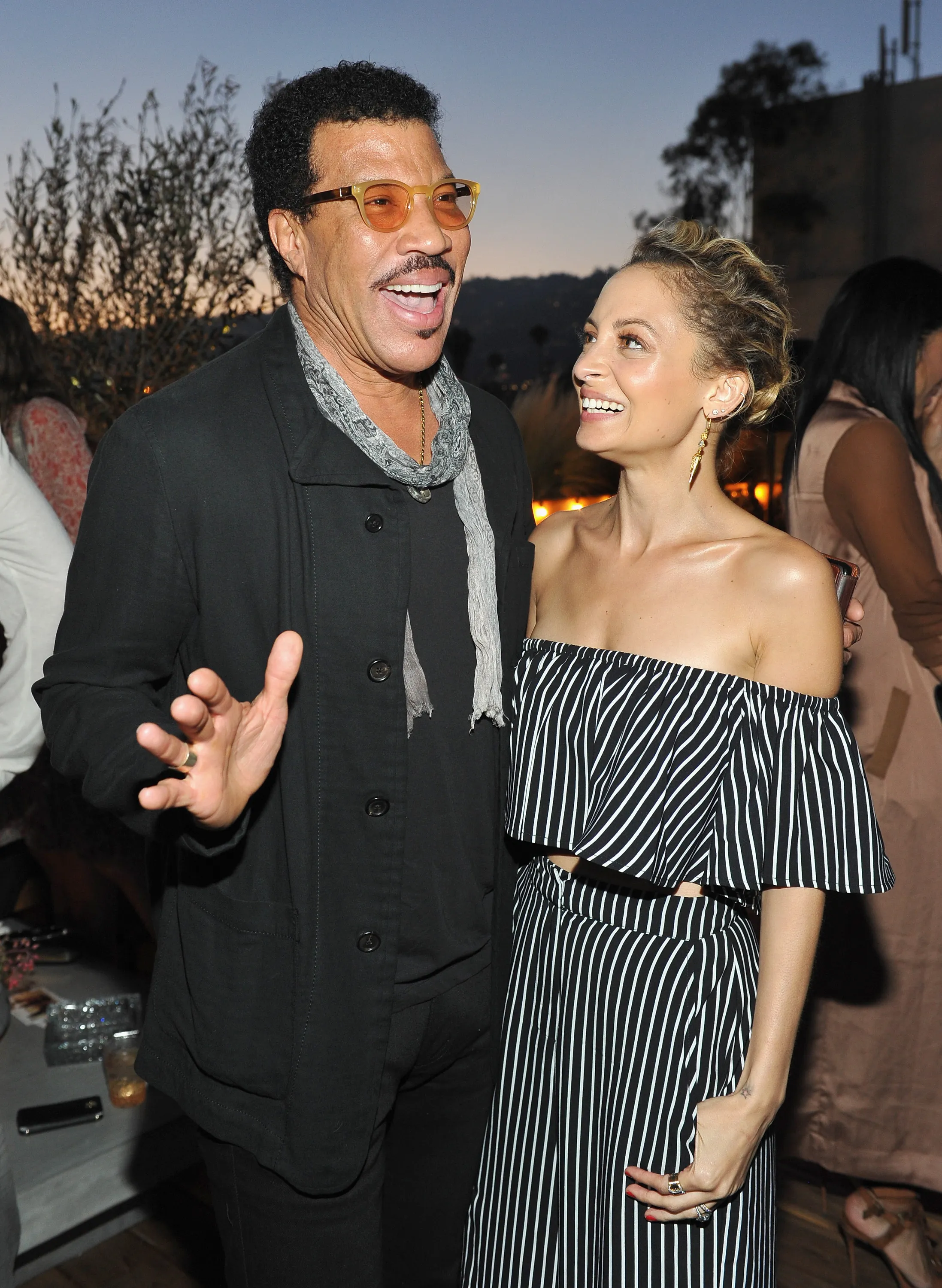 Singer-songwriter Lionel Richie and fashion designer Nicole Richie smiling at an event.