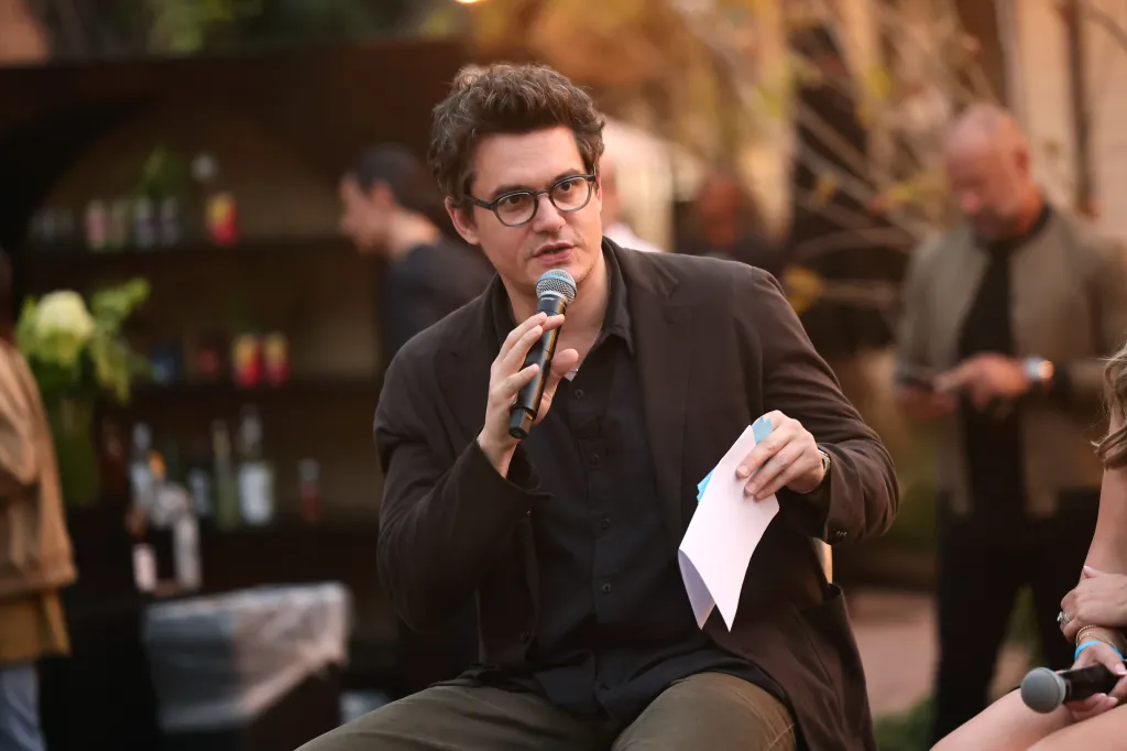 John Mayer speaking onstage at a private concert benefiting The Heart and Armor Foundation.