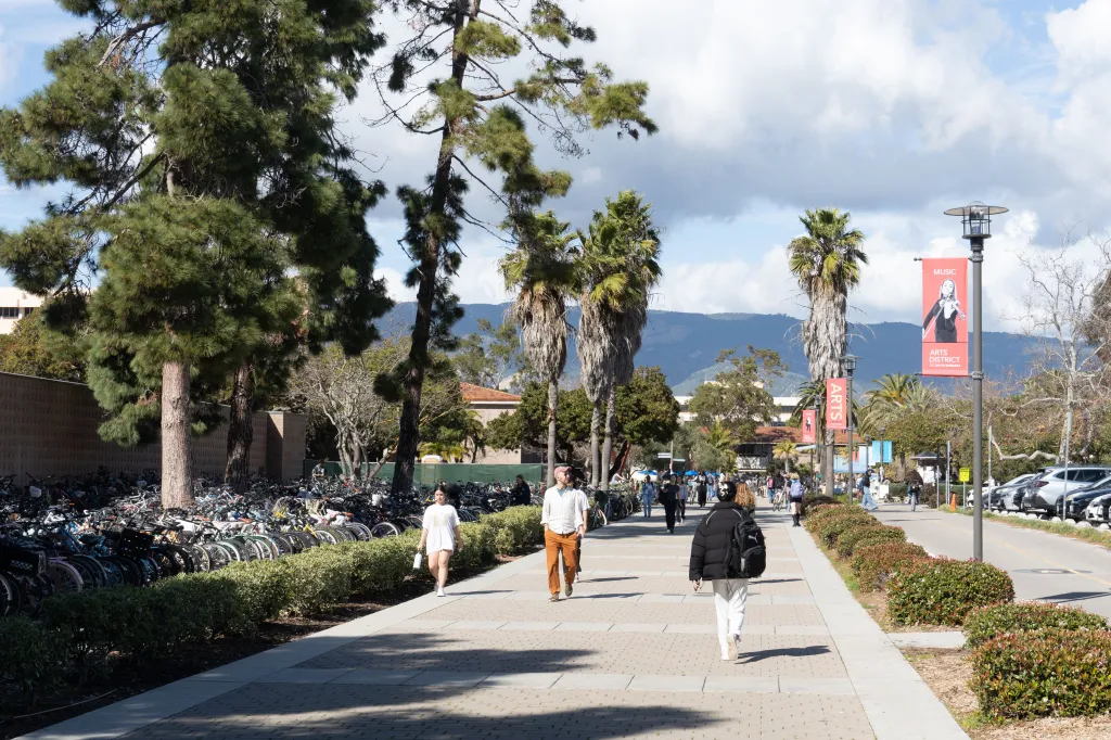 Students walk along a paved pathway at the University of California, Santa Barbara.
