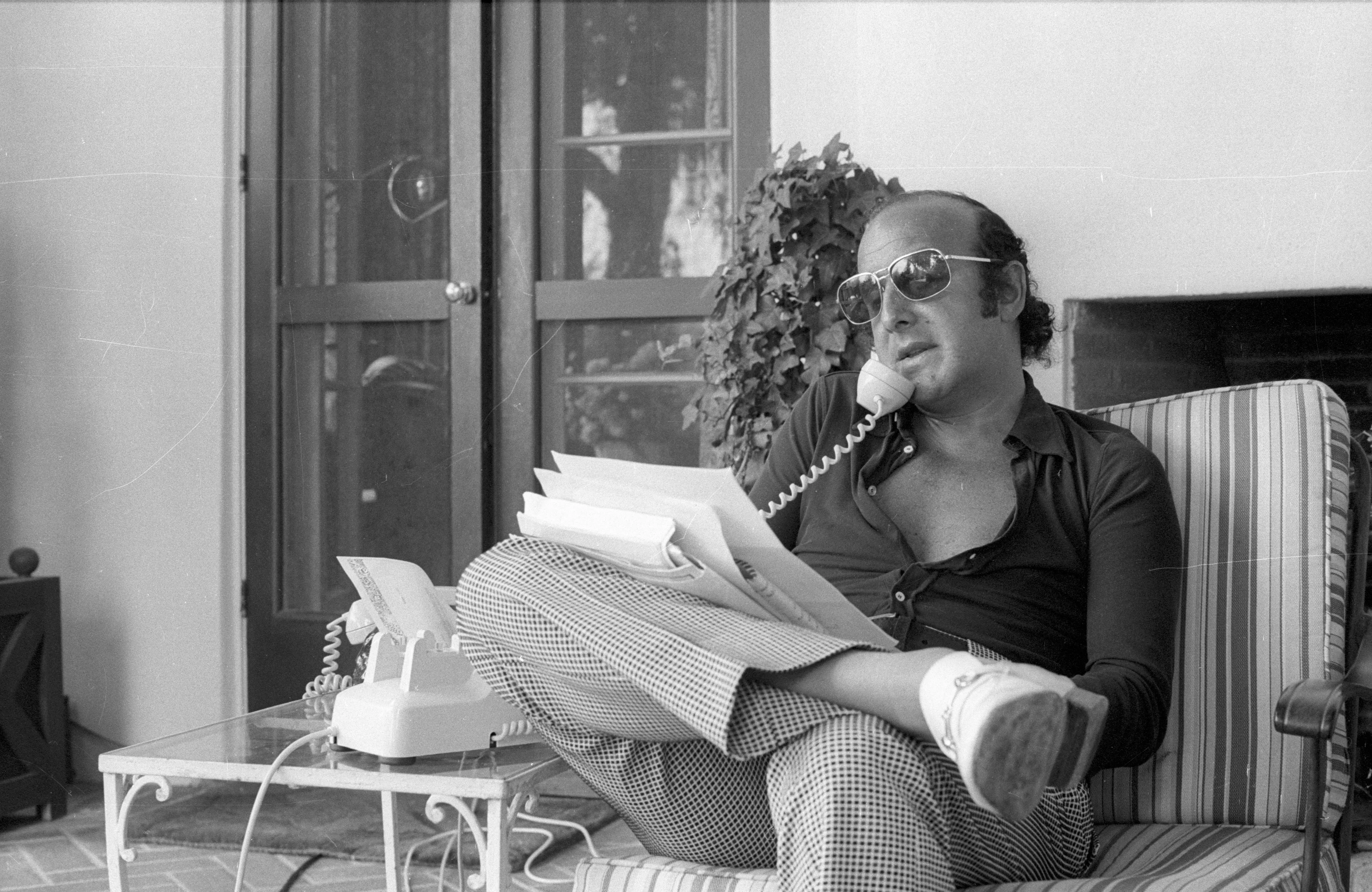 Clive Davis talking on the phone in a black and white photo.