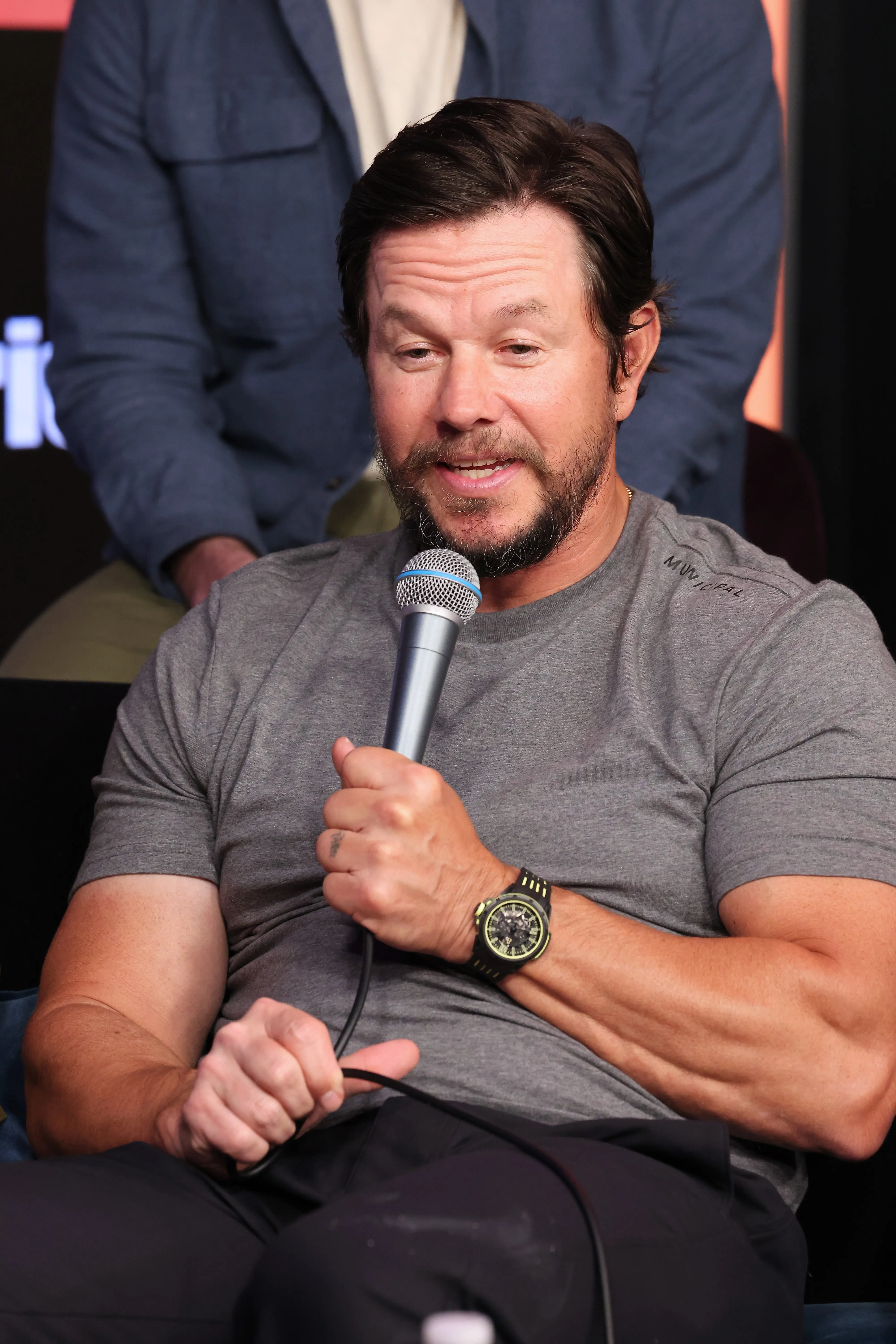 Mark Wahlberg speaks into a microphone.