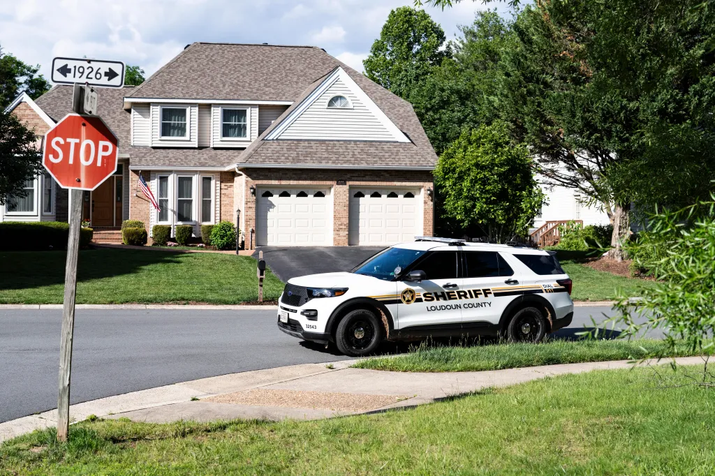 Sheriff's vehicle parked on a street in front of a suburban home.
