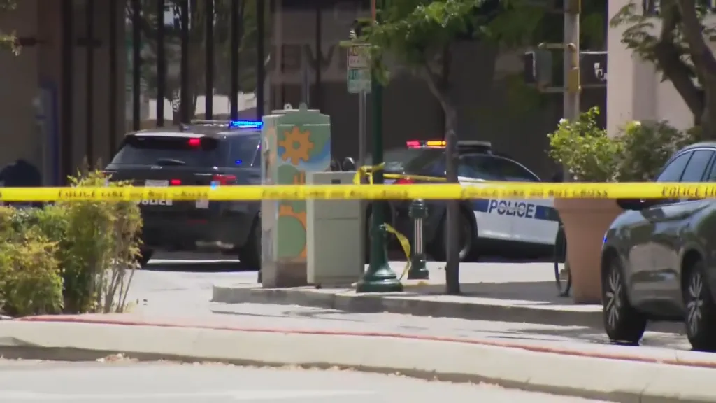 Police cars and crime scene tape blocking off a downtown street.