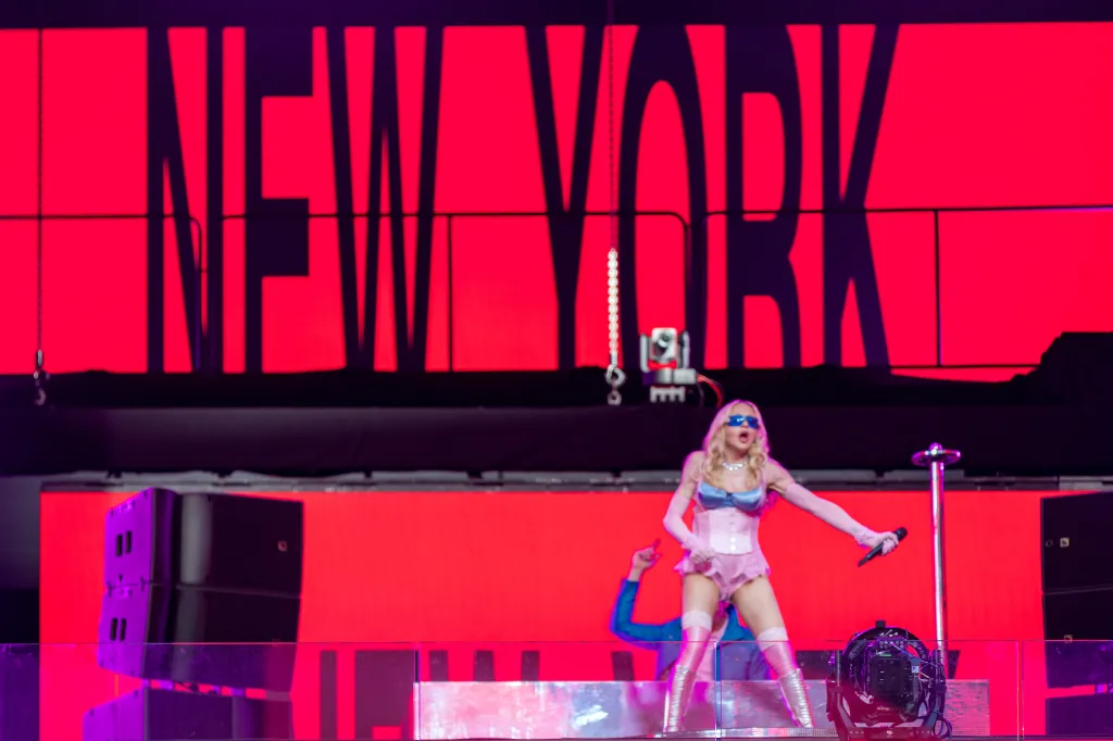 Popstar Madonna performing a pop-up concert in Times Square with a red 