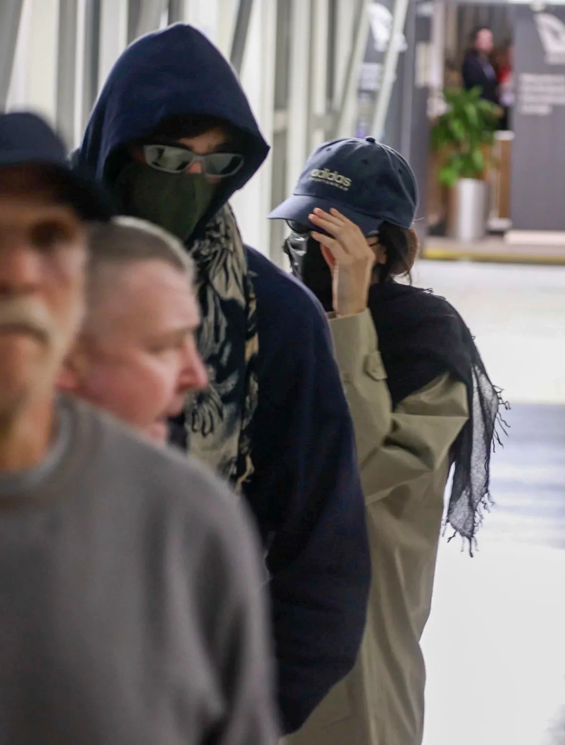 Jacob Elordi and Kendall Jenner in hoodies, sunglasses, and face masks at Brisbane Airport.