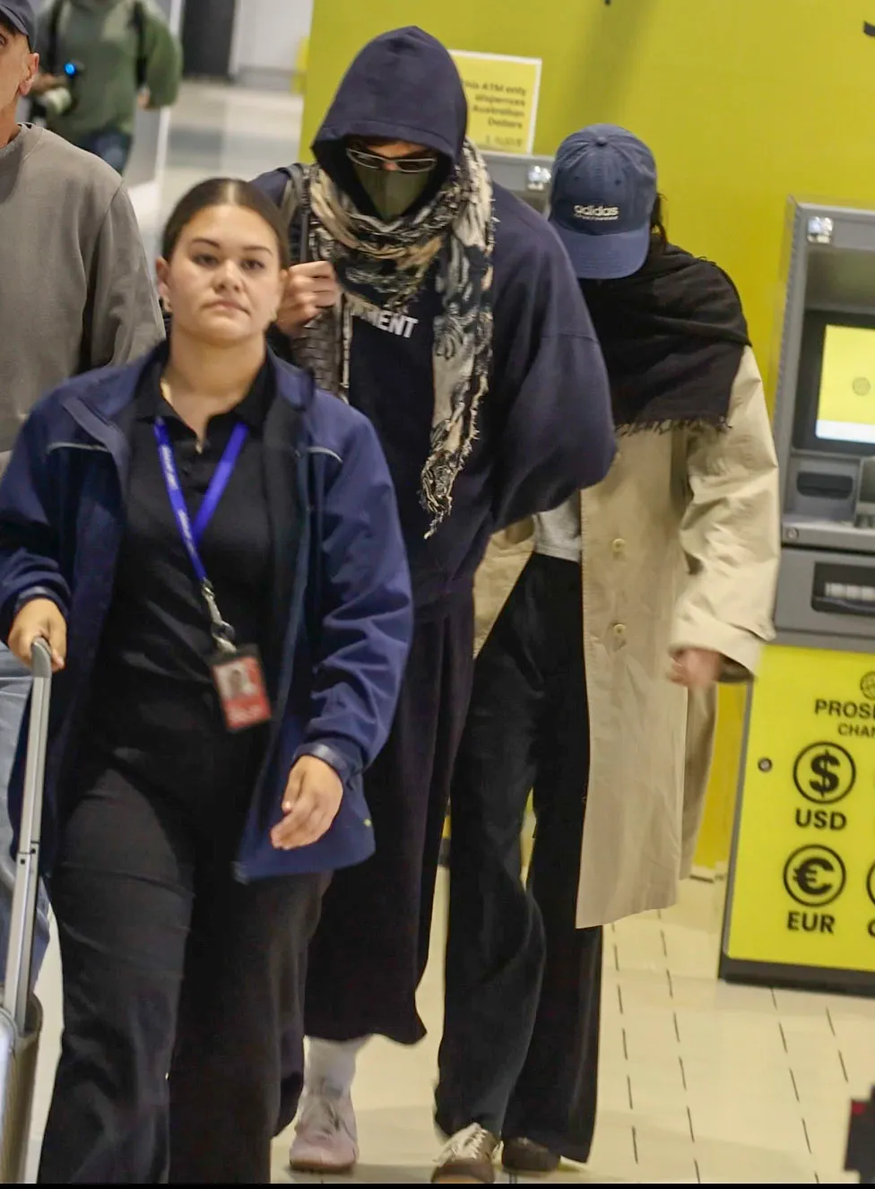 Jacob Elordi and Kendall Jenner, disguised in hoodies, scarves, masks, and sunglasses, depart Brisbane Airport.