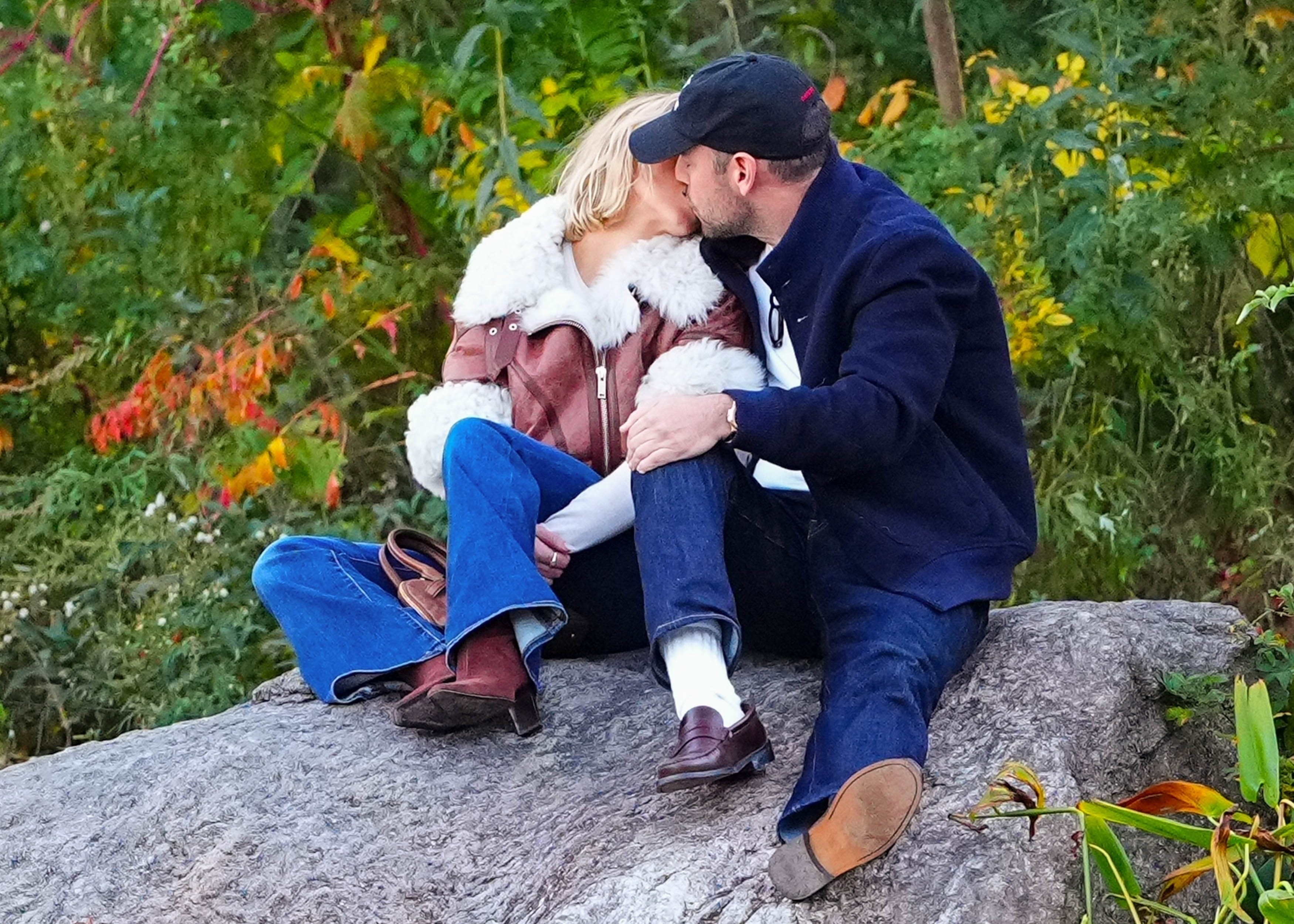 Sydney Sweeney and Scooter Braun kissing on a rock.