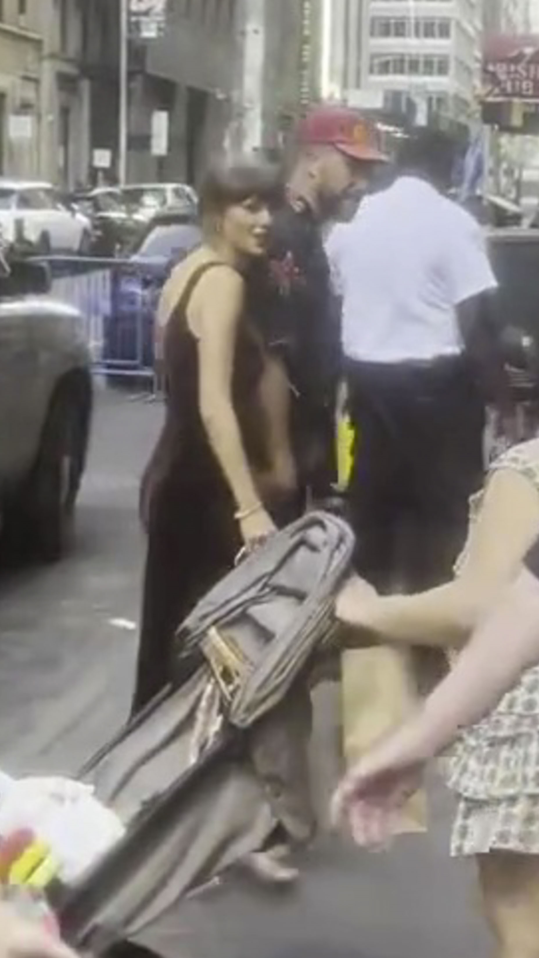 Taylor Swift and Travis Kelce walking together in Times Square.