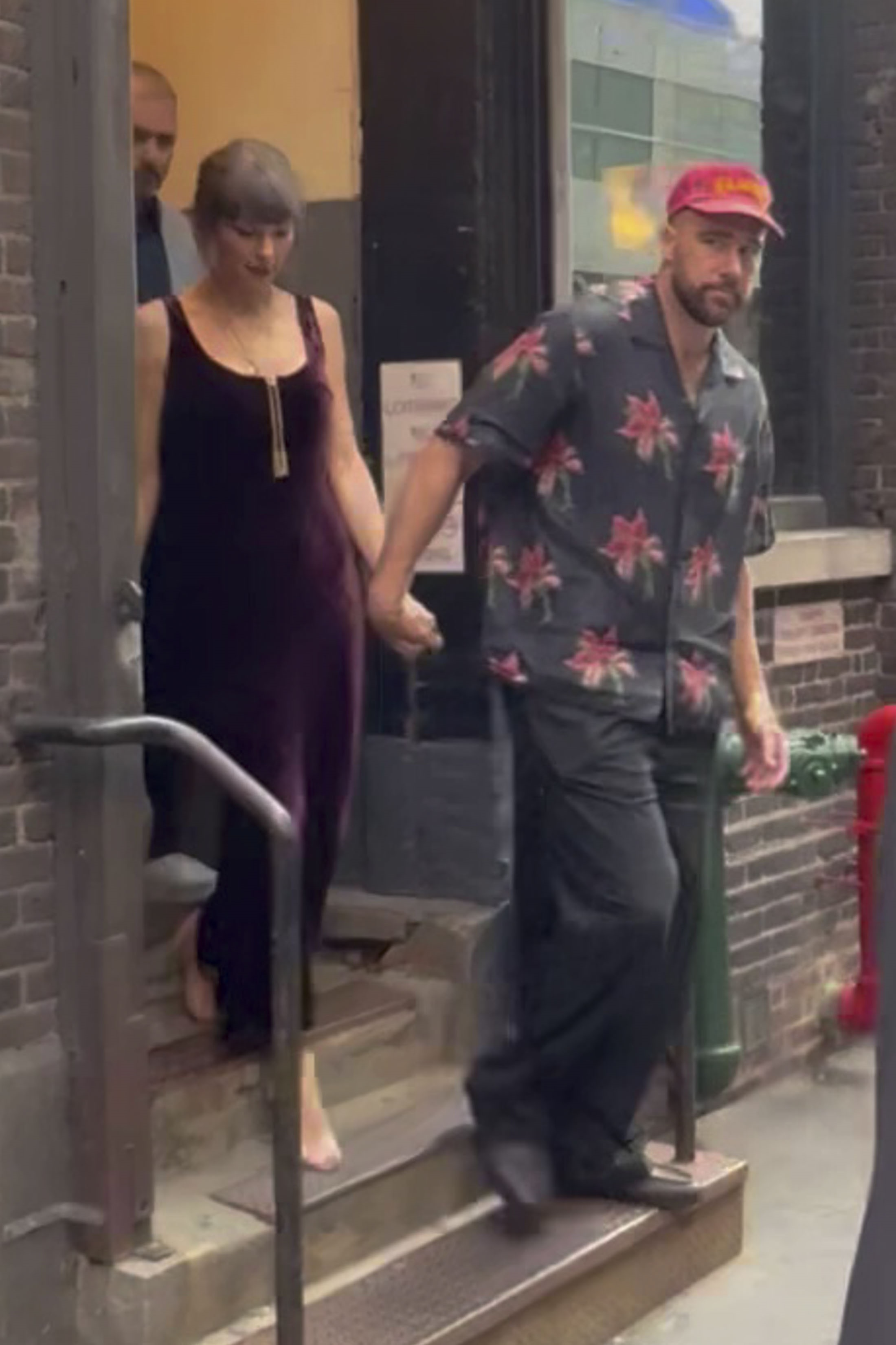 Taylor Swift and Travis Kelce leaving a restaurant, holding hands.