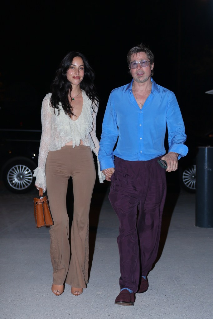 Brad Pitt and Ines de Ramon holding hands and walking together.