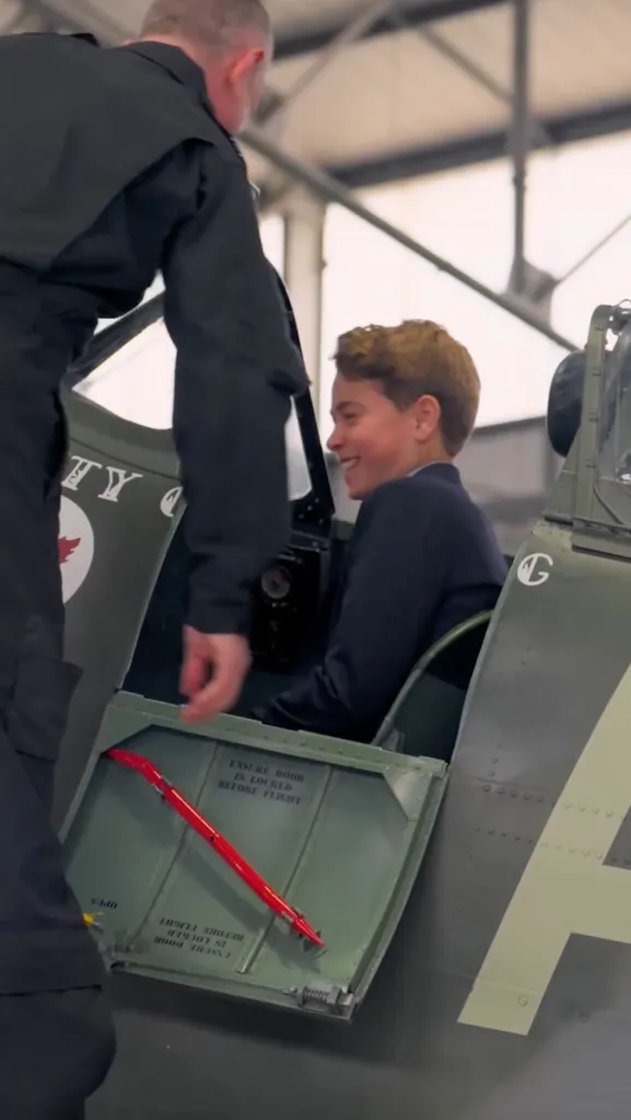 Prince George laughing in the cockpit of a plane.