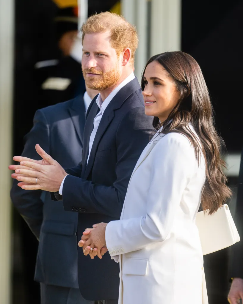 Prince Harry, Duke of Sussex, and Meghan, Duchess of Sussex, applaud at a reception for Invictus Games competitors.