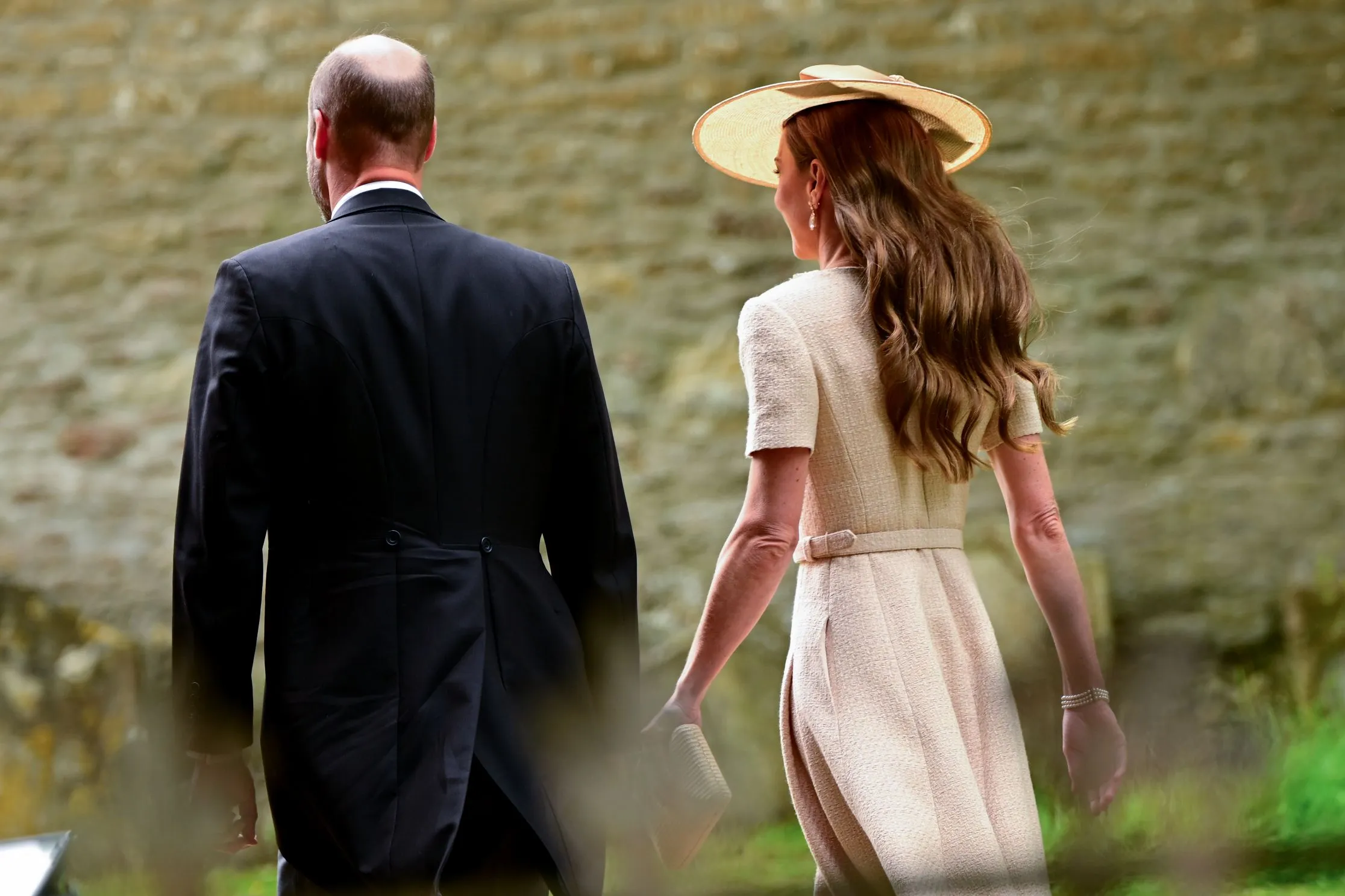 Prince William and Catherine, Princess of Wales, walking away from the camera.