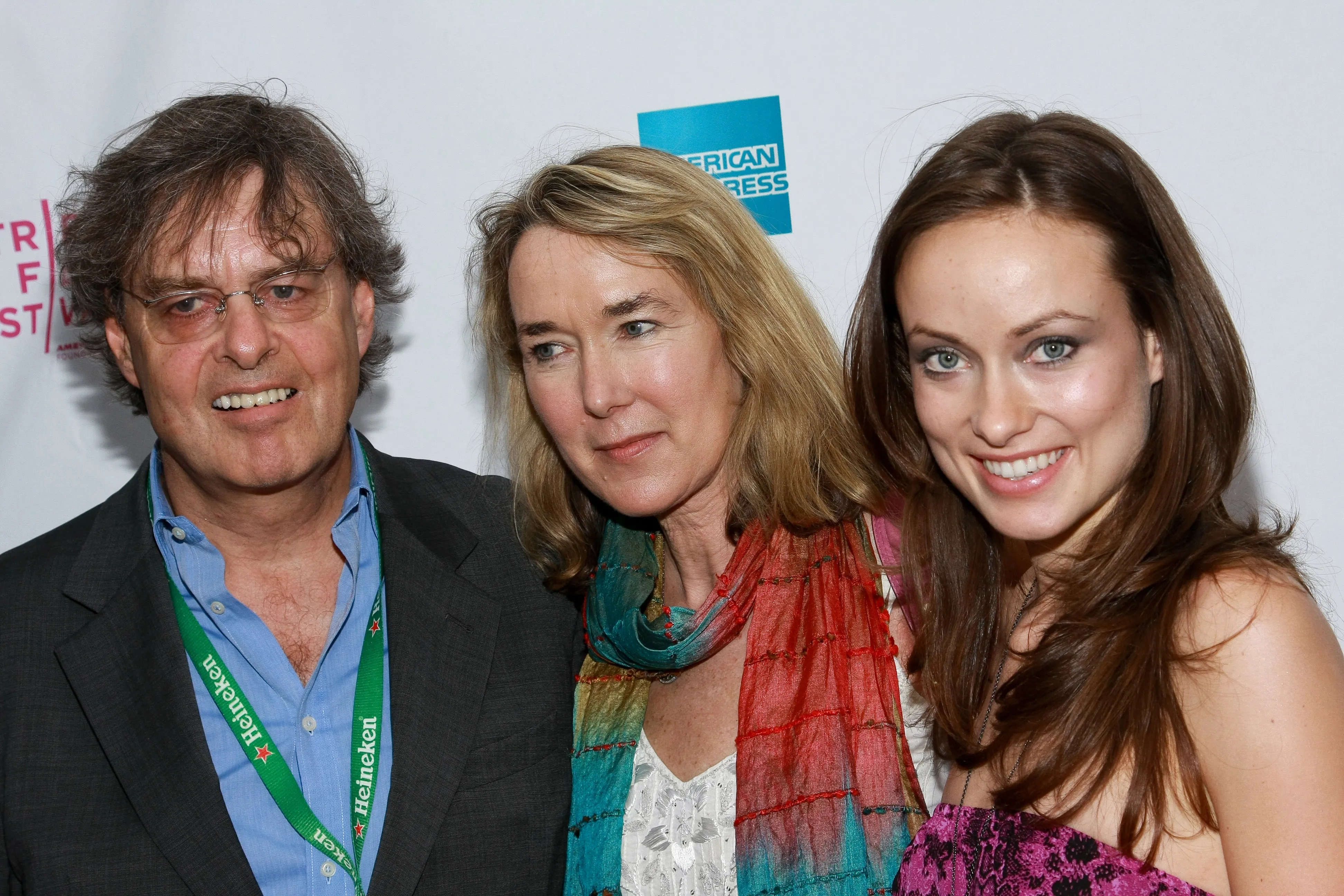 Producer Andrew Cockburn, director Leslie Cockburn, and actress Olivia Wilde smiling at the 