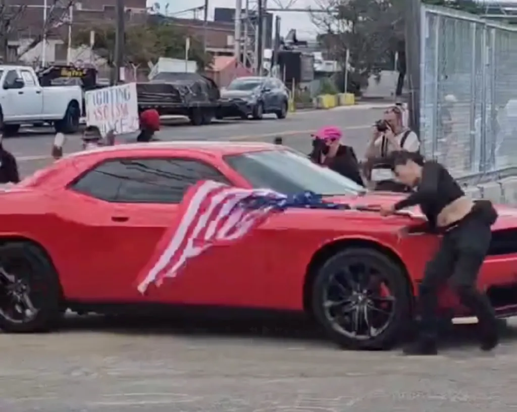 The protester was waving an upside-down American flag when she was hit, video shows.