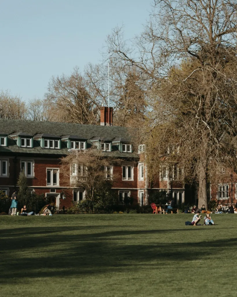 Reed College building with students sitting on the lawn.