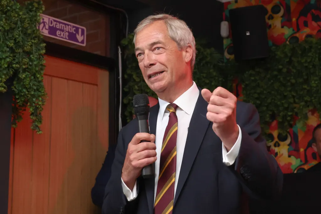 Nigel Farage, leader of Reform UK, speaks into a microphone at Chapo's pub in Ashton-In-Makerfield, Greater Manchester.