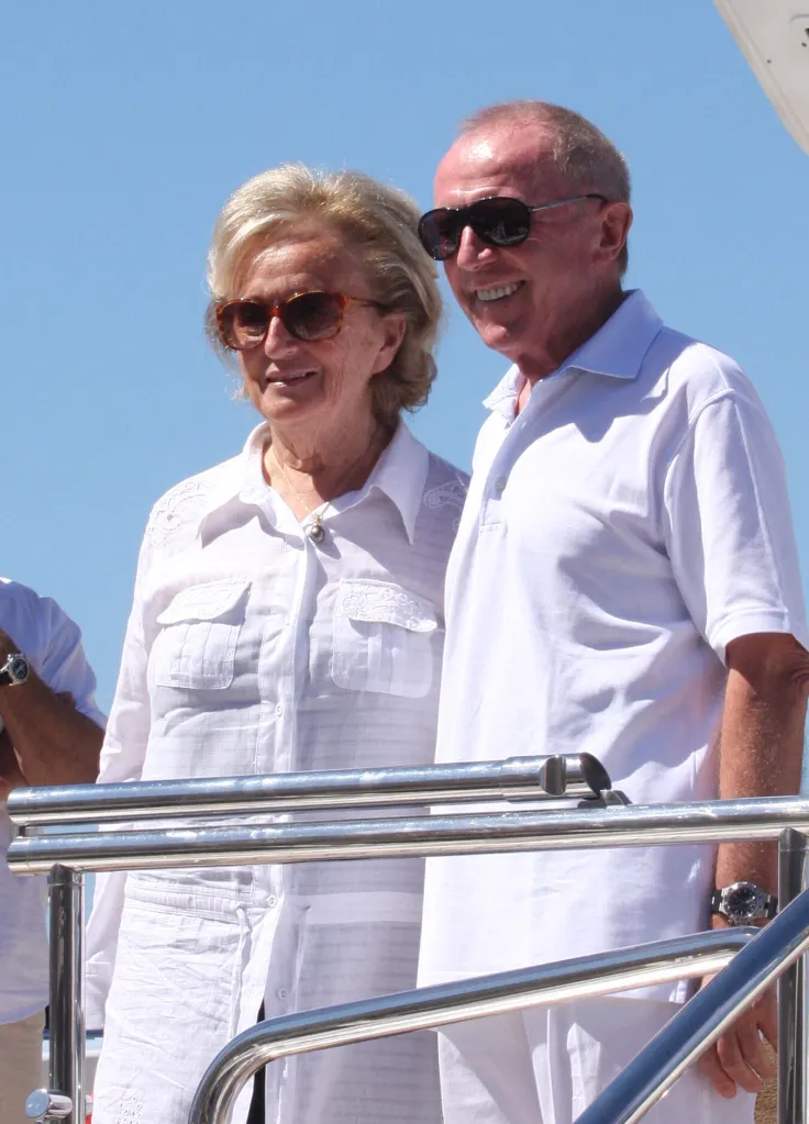 Bernadette Chirac and a man in sunglasses stand next to each other on a boat.