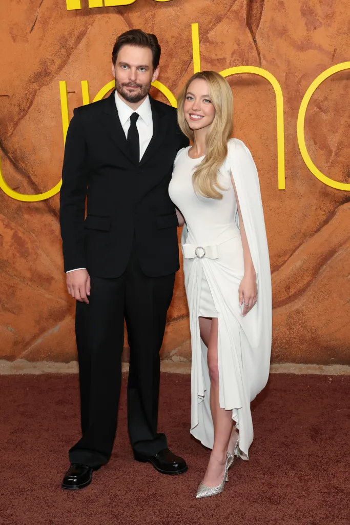 Sam Levinson in a black suit and Sydney Sweeney in a white dress at the premiere of 