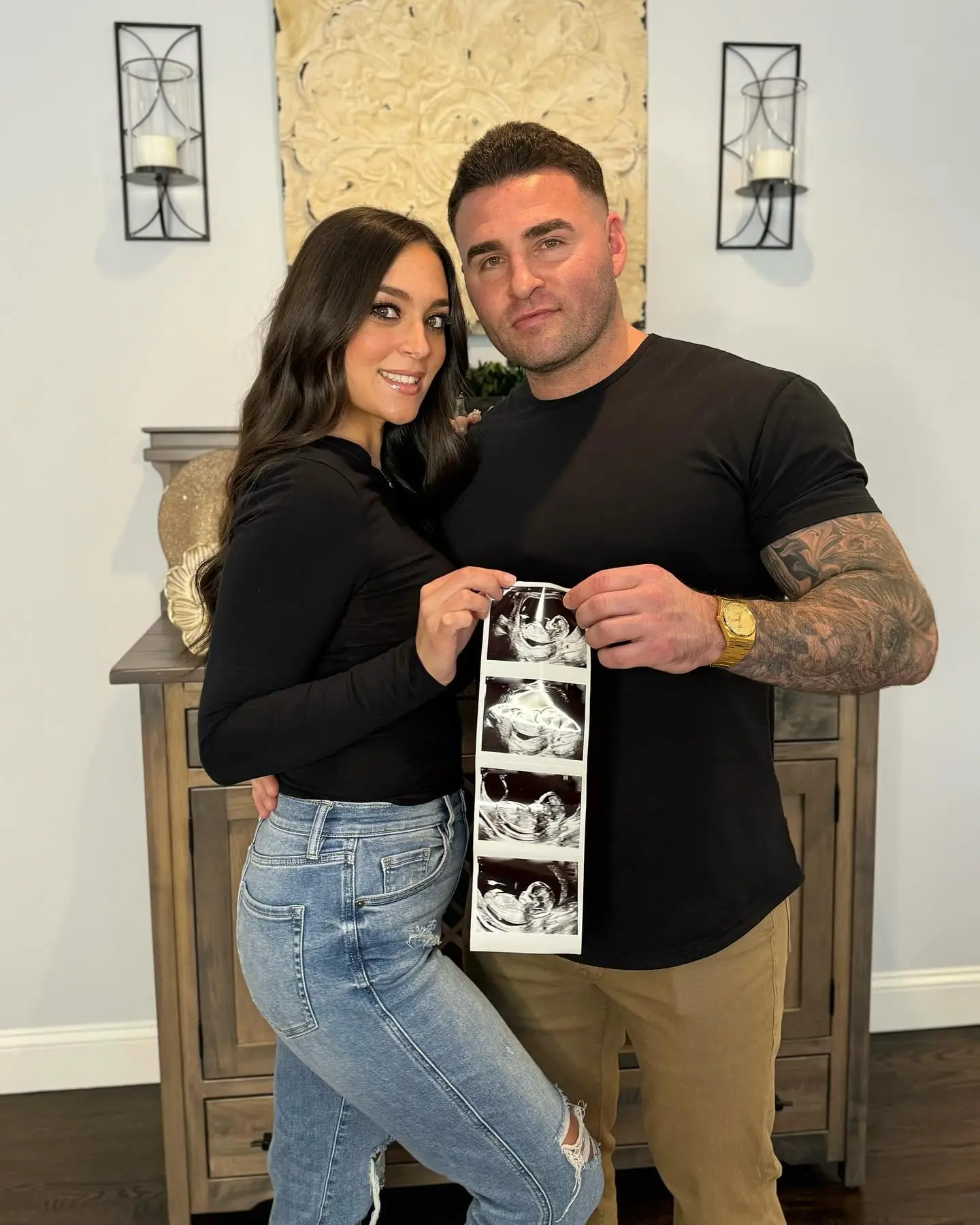 Sammi Sweetheart Giancola and Justin May holding up a strip of sonogram images.
