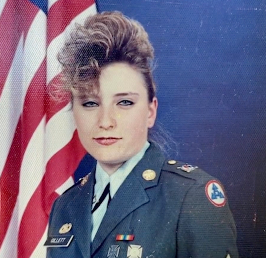 Brenda Gillett, an Army veteran, in her military uniform with an American flag behind her.
