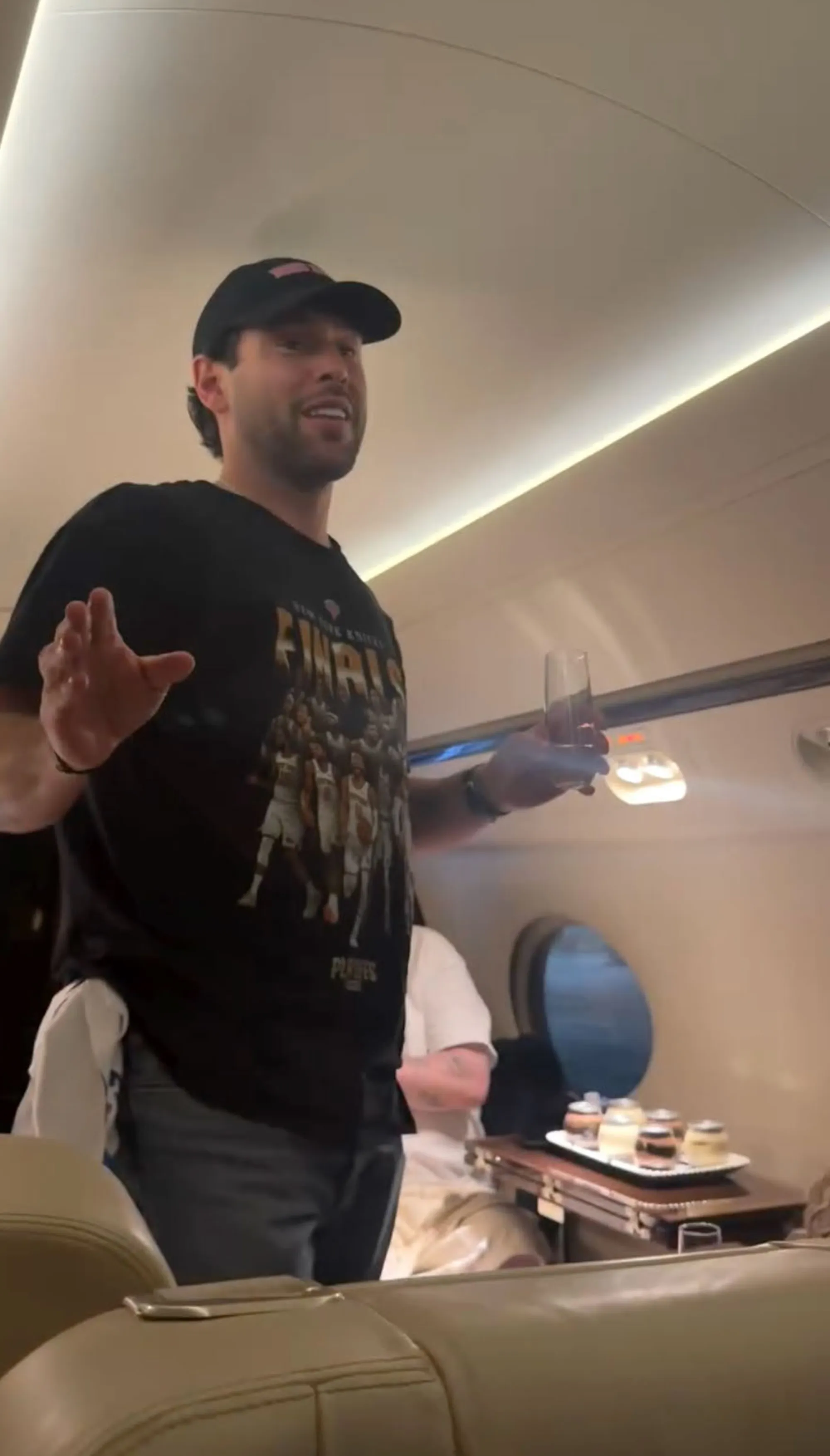 Scooter Braun holding a champagne flute on a private jet.