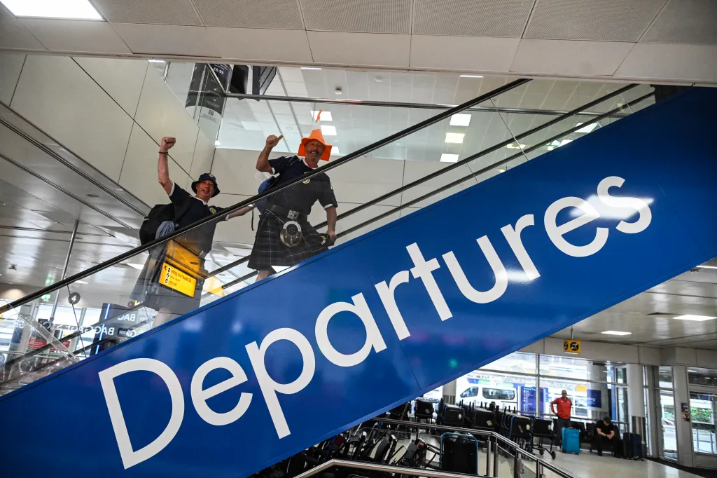 Two jubilant Scotland football fans on an escalator under a 