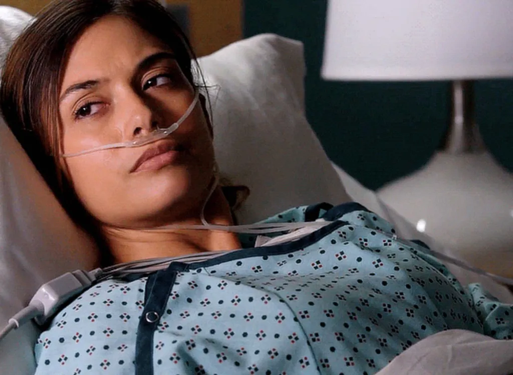 Justene Alpert as a patient wearing a hospital gown and a nasal cannula in 9-1-1 season 5 episode 9.