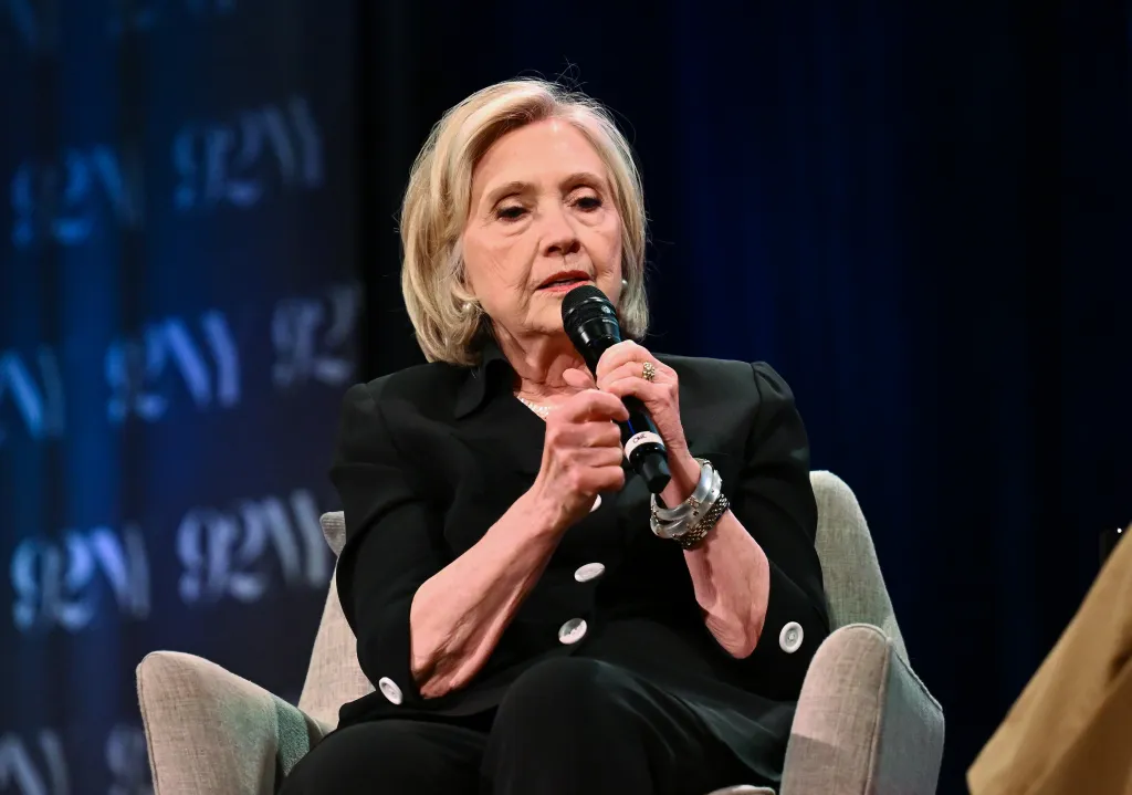 Hillary Rodham Clinton speaking at an event, holding a microphone.