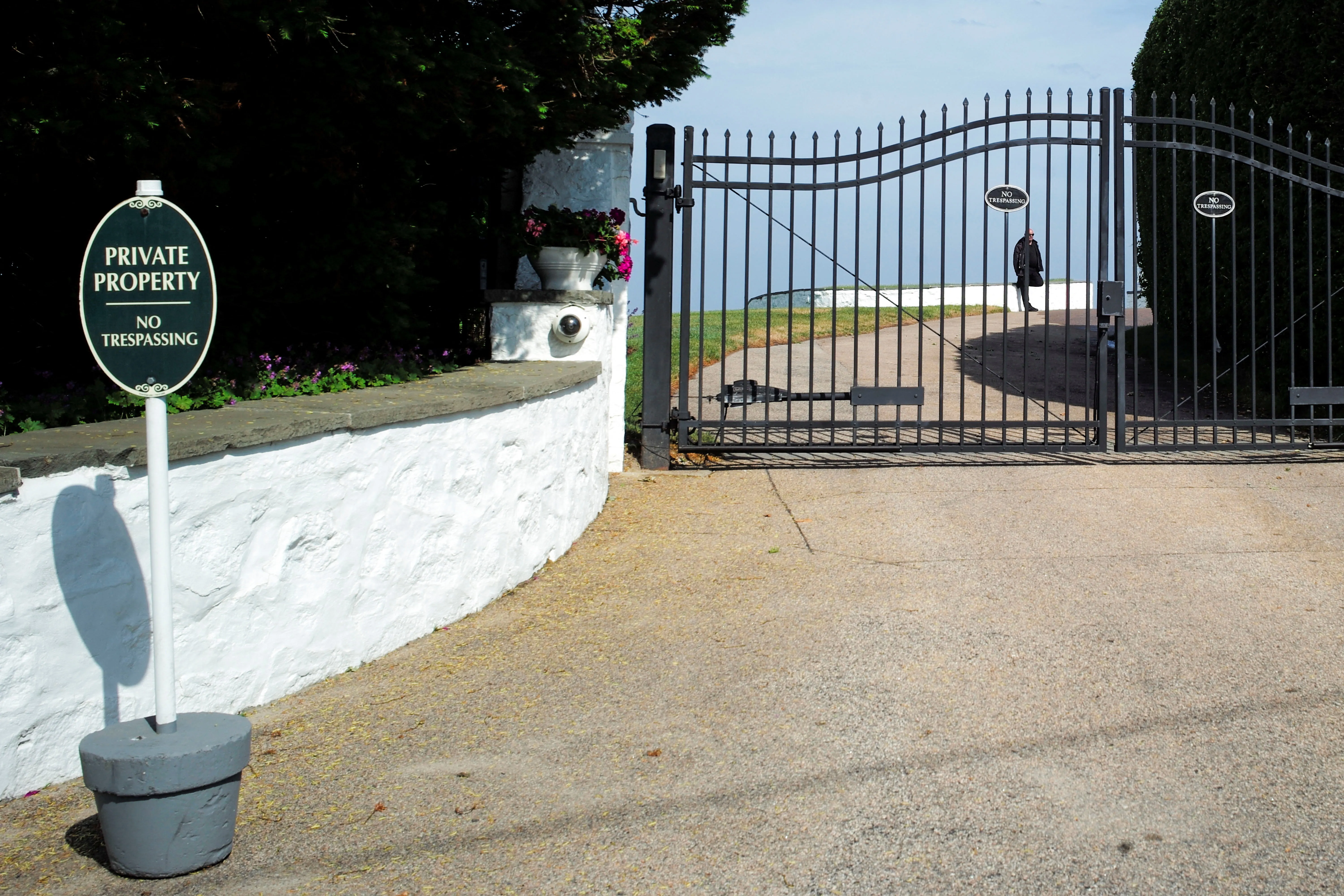 A security guard stands watch at the drive entrance gate of Taylor Swift's home.