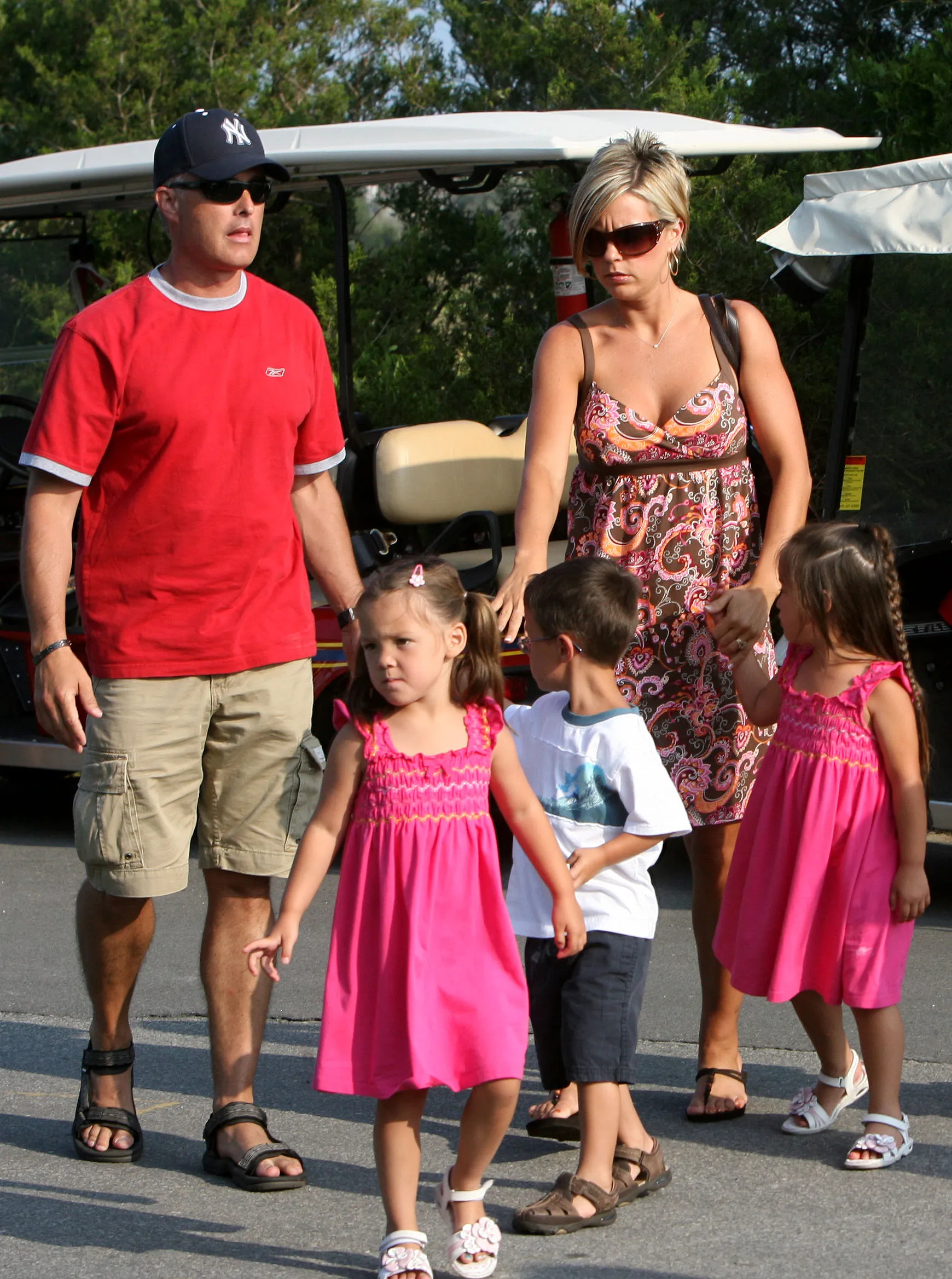 Kate Gosselin and bodyguard Steve Neild walking with four of her children next to a golf cart.