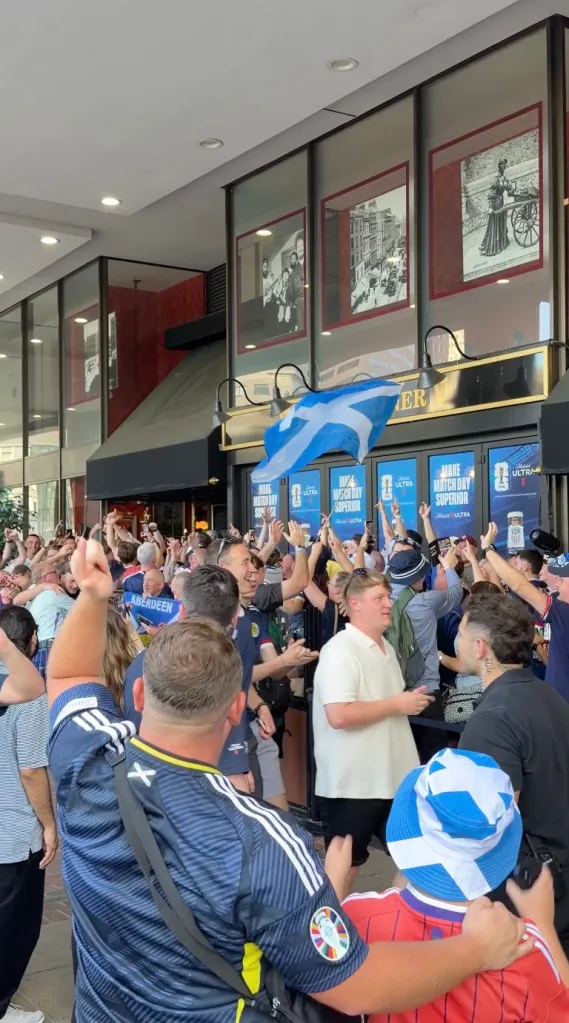 Scottish soccer fans celebrating outside a pub.