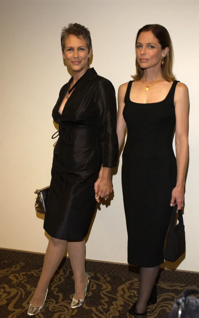 Jamie Lee Curtis and Kelly Curtis, both in black dresses, holding hands.