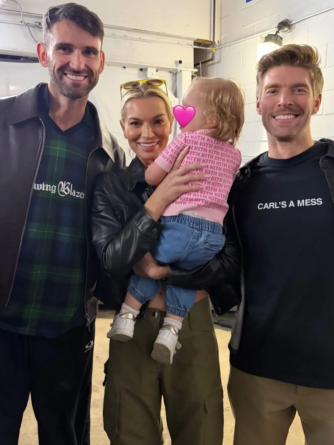 Carl Radke, Lindsay Hubbard, and Kyle Cooke posing with a baby whose face is obscured by a pink heart emoji.