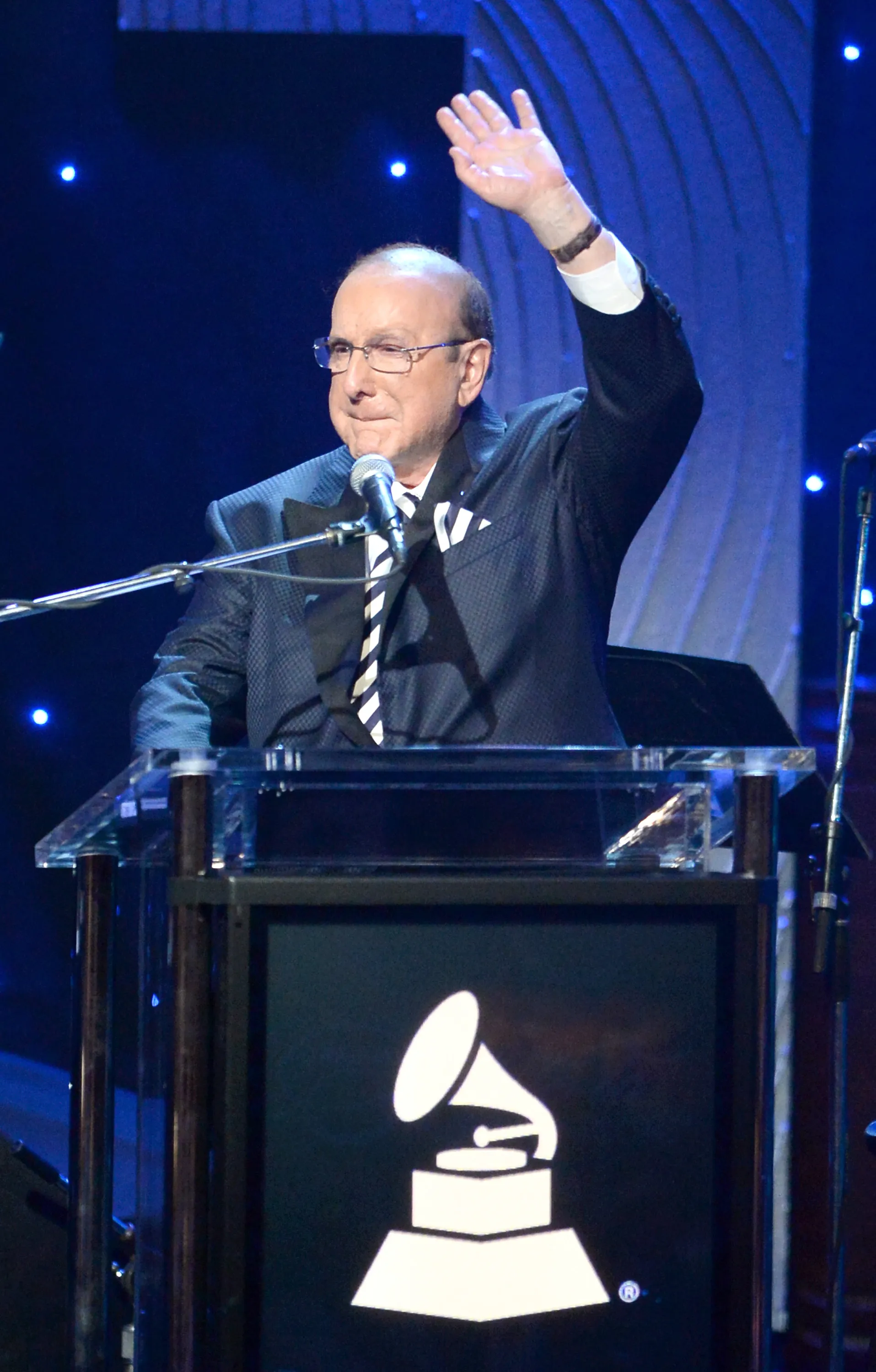 Sony Music Chief Creative Officer Clive Davis speaks at a podium with a GRAMMY logo.