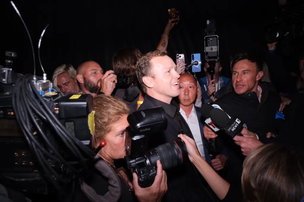 Spencer Pratt speaking to reporters and photographers at an election event.