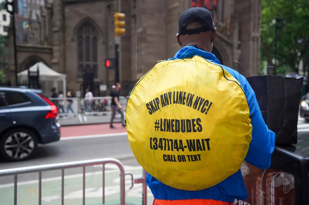 The back of a man wearing a yellow circular sign that reads 