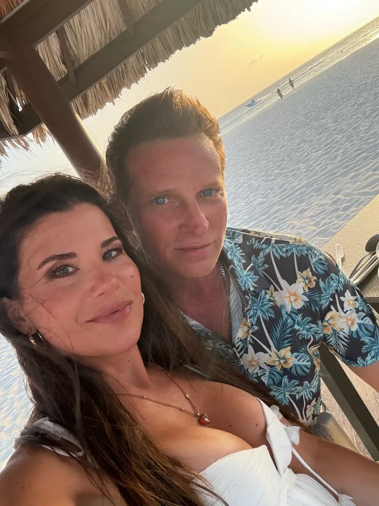 Steve and Michelle Burton taking a selfie with a beach sunset in the background.