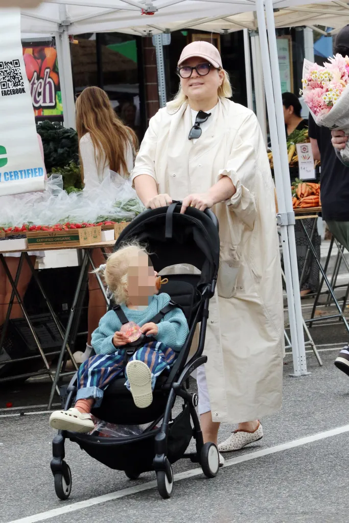 Sia pushing her son, Somersault Wonder Bernad, in a stroller at a farmers market.
