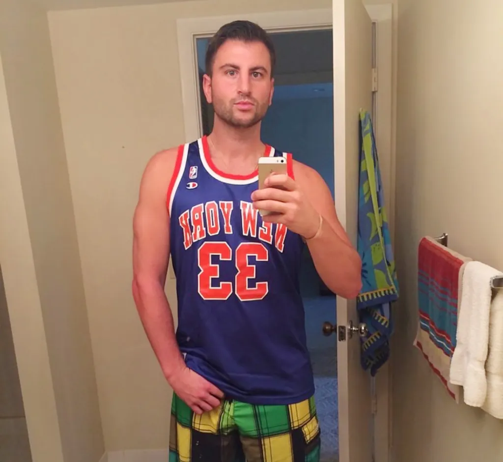 Evan Perlmutter, in a New York Knicks jersey, takes a selfie in a mirror.
