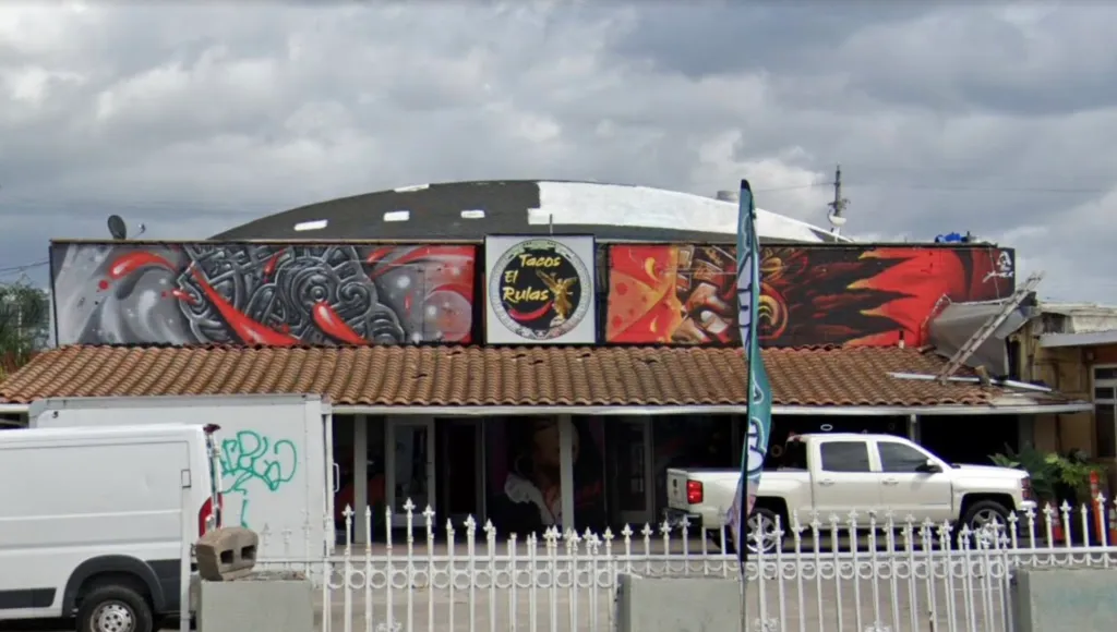 Exterior view of Tacos El Rulas, with a colorful mural above its entrance.