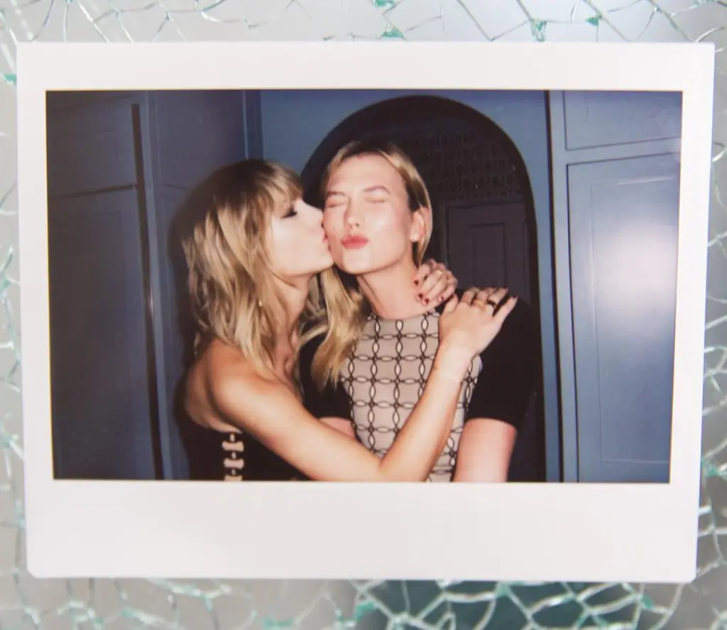 Taylor Swift kissing Karlie Kloss on the cheek.
