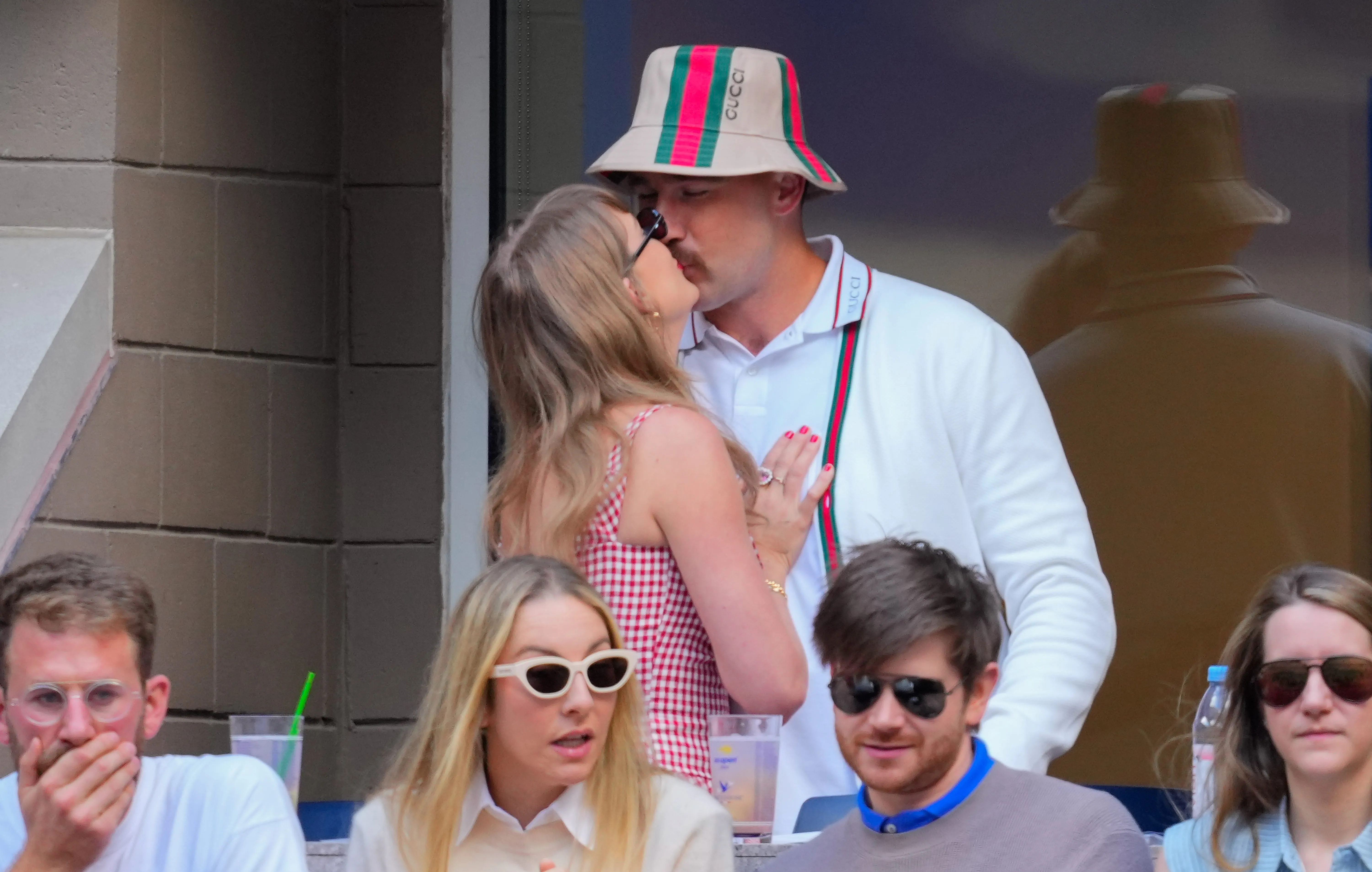 Taylor Swift and Travis Kelce kiss while attending the 2024 US Open Tennis Championships.