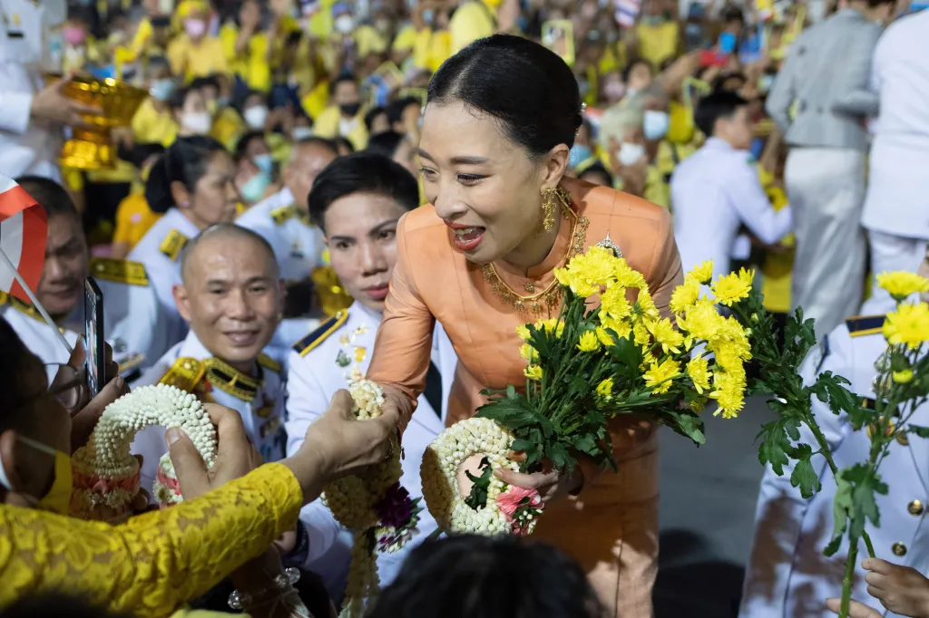 Thai Princess Bajrakitiyabha Mahidol shakes hands with supporters and holds flowers in Bangkok.