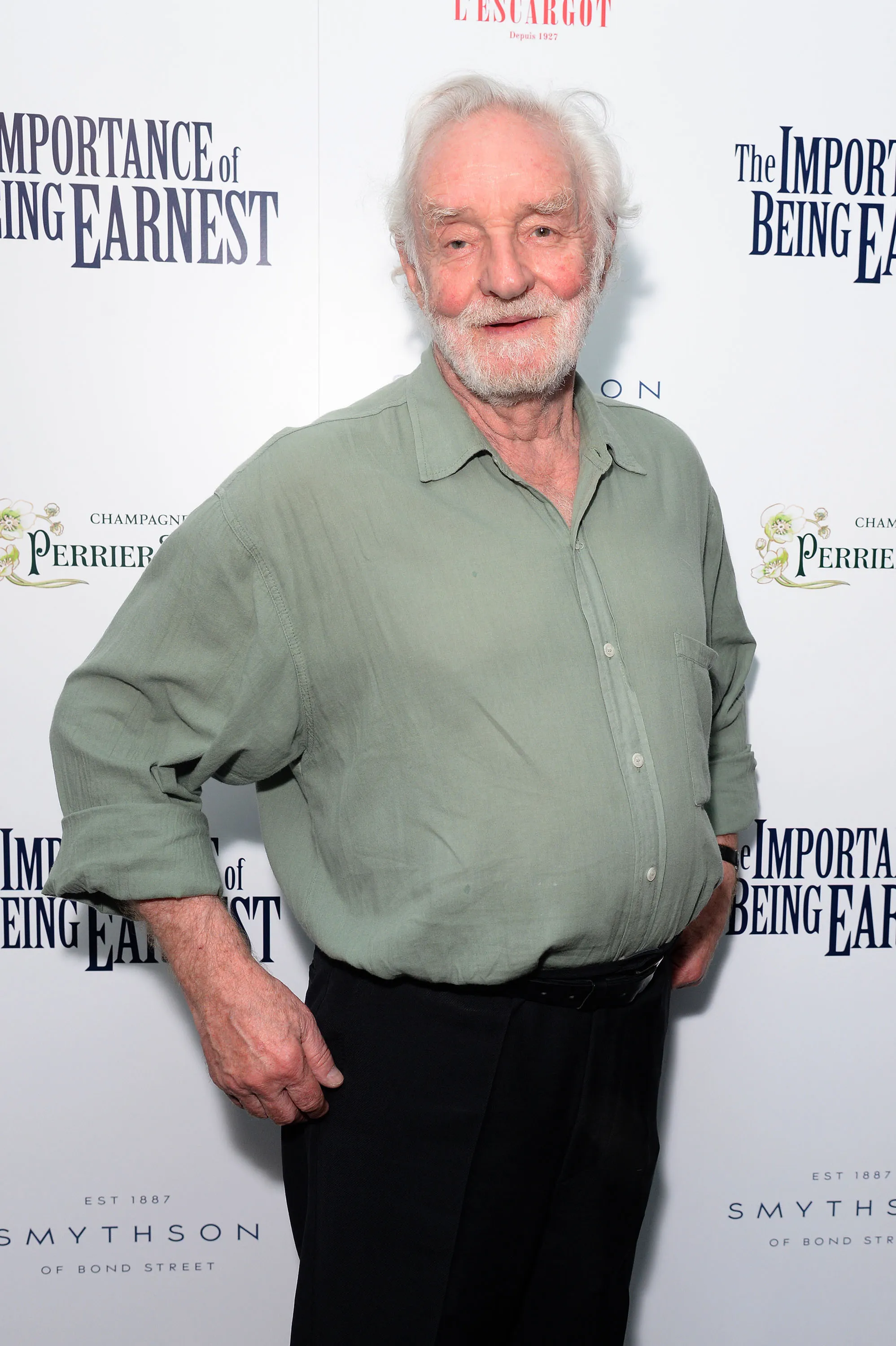 Patrick Godfrey posing in front of a banner for 