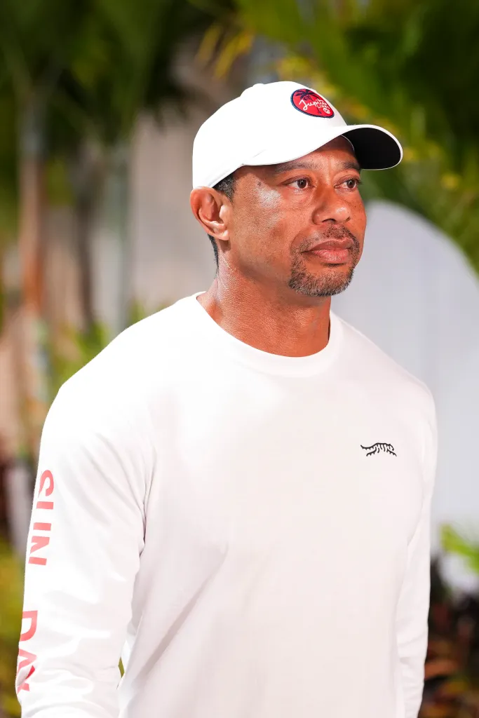 Tiger Woods in a white long-sleeved shirt and white cap, with 