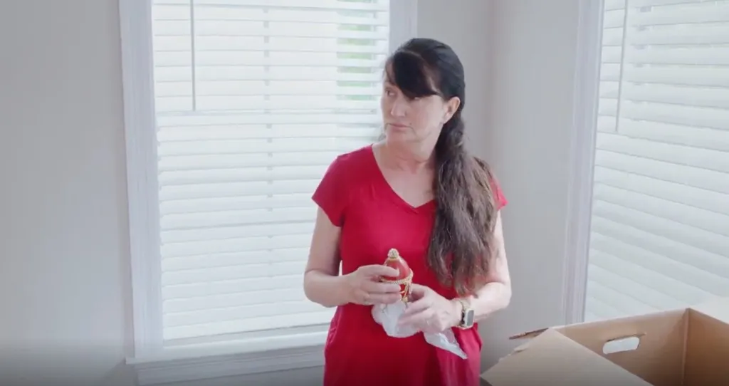 Debbie from 90 Day Fiancé holding a small decorative egg.