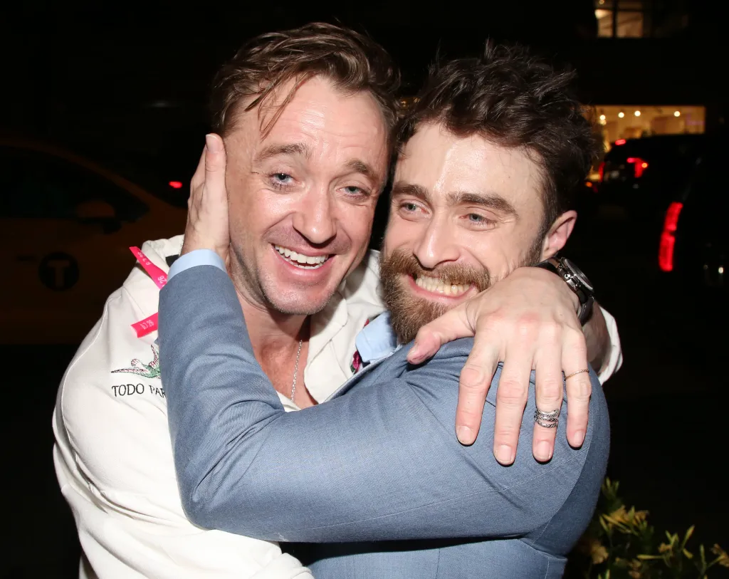 Tom Felton and Daniel Radcliffe embrace at an awards after-party.